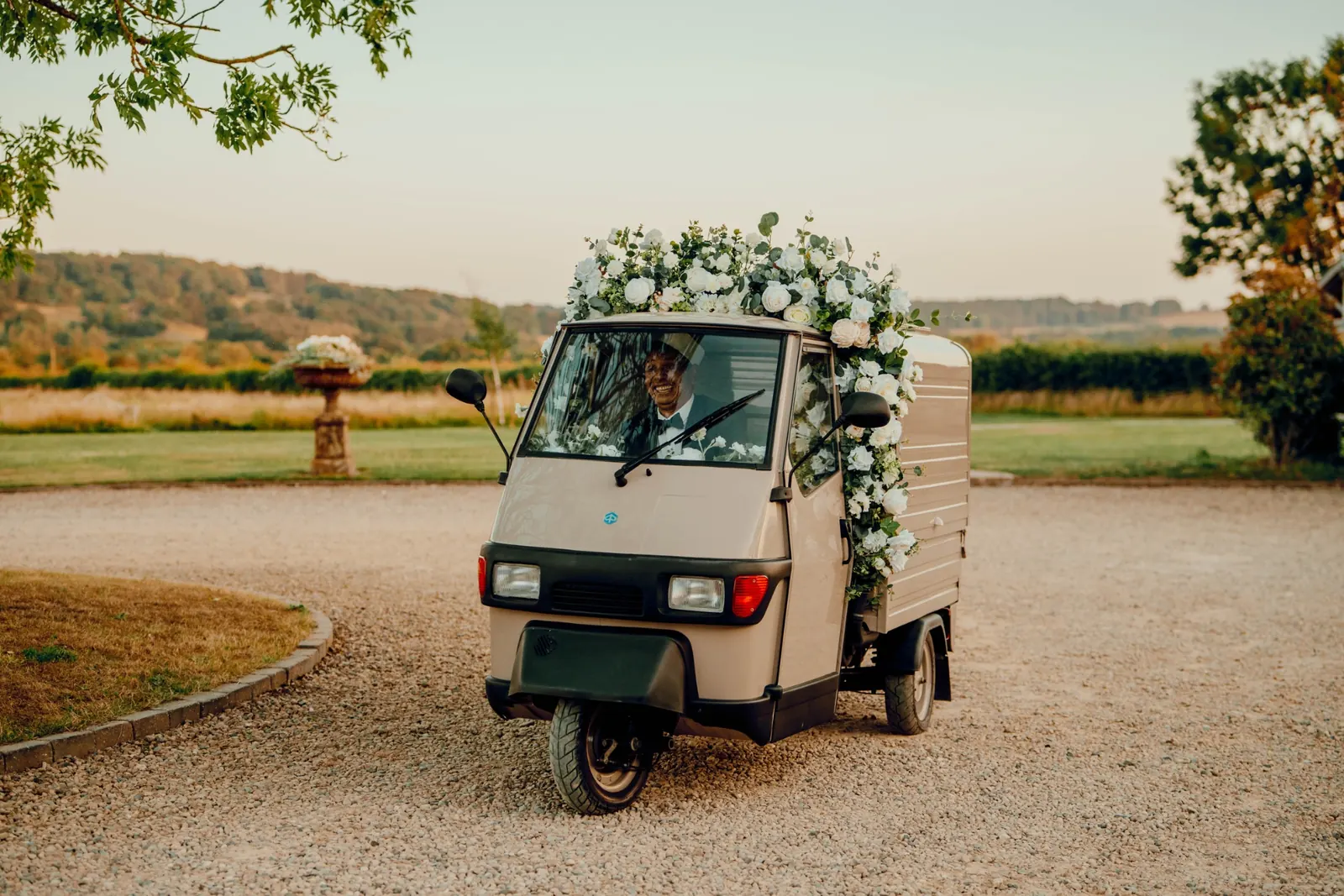 Vintage floral tuk-tuk ice cream cart at a countryside wedding venue