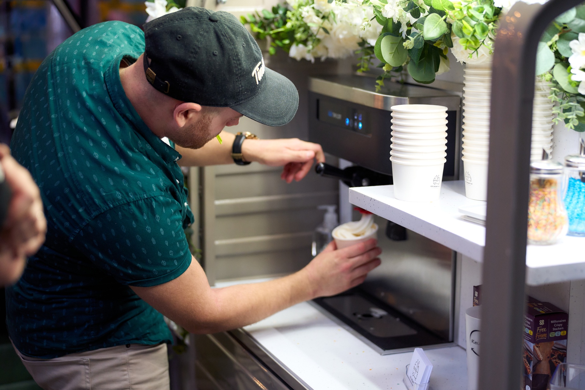 Attendant serving soft-serve ice cream from the tuk-tuk at a wedding