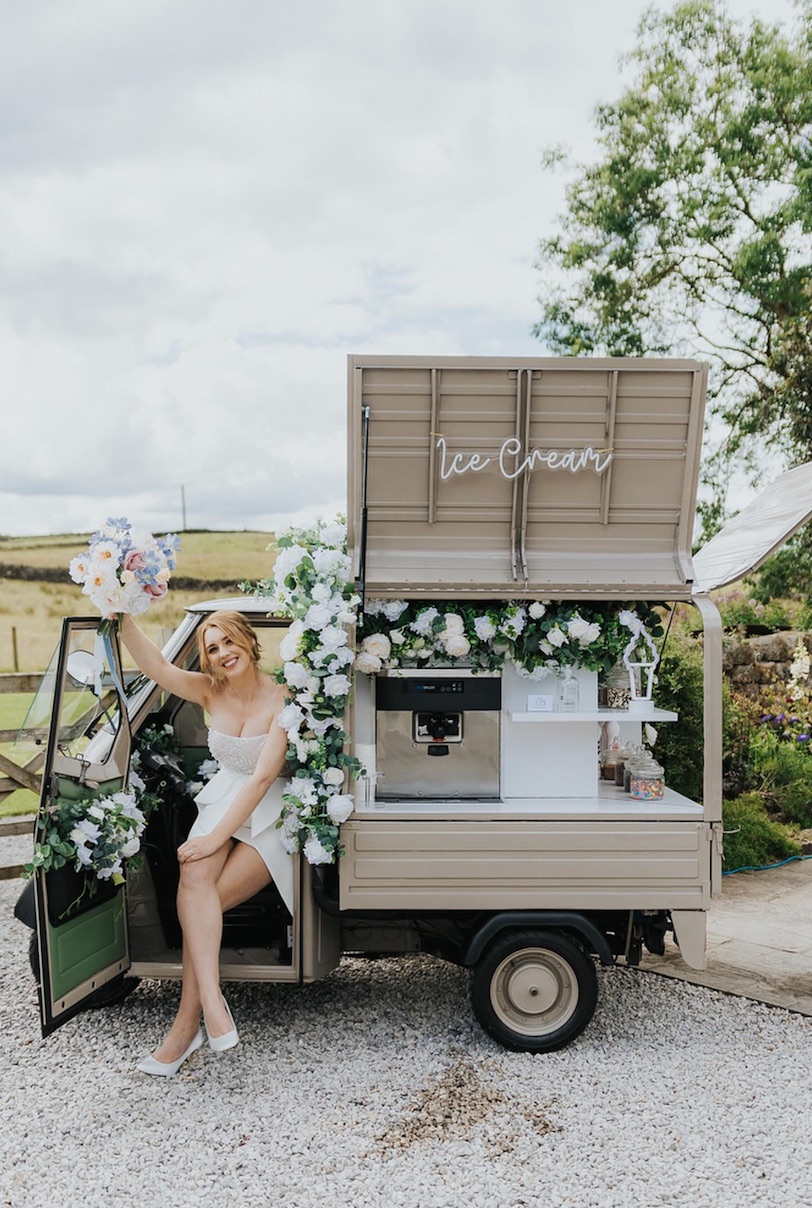 Bride in the driver's seat of the Ice Cream Tuk wedding cart